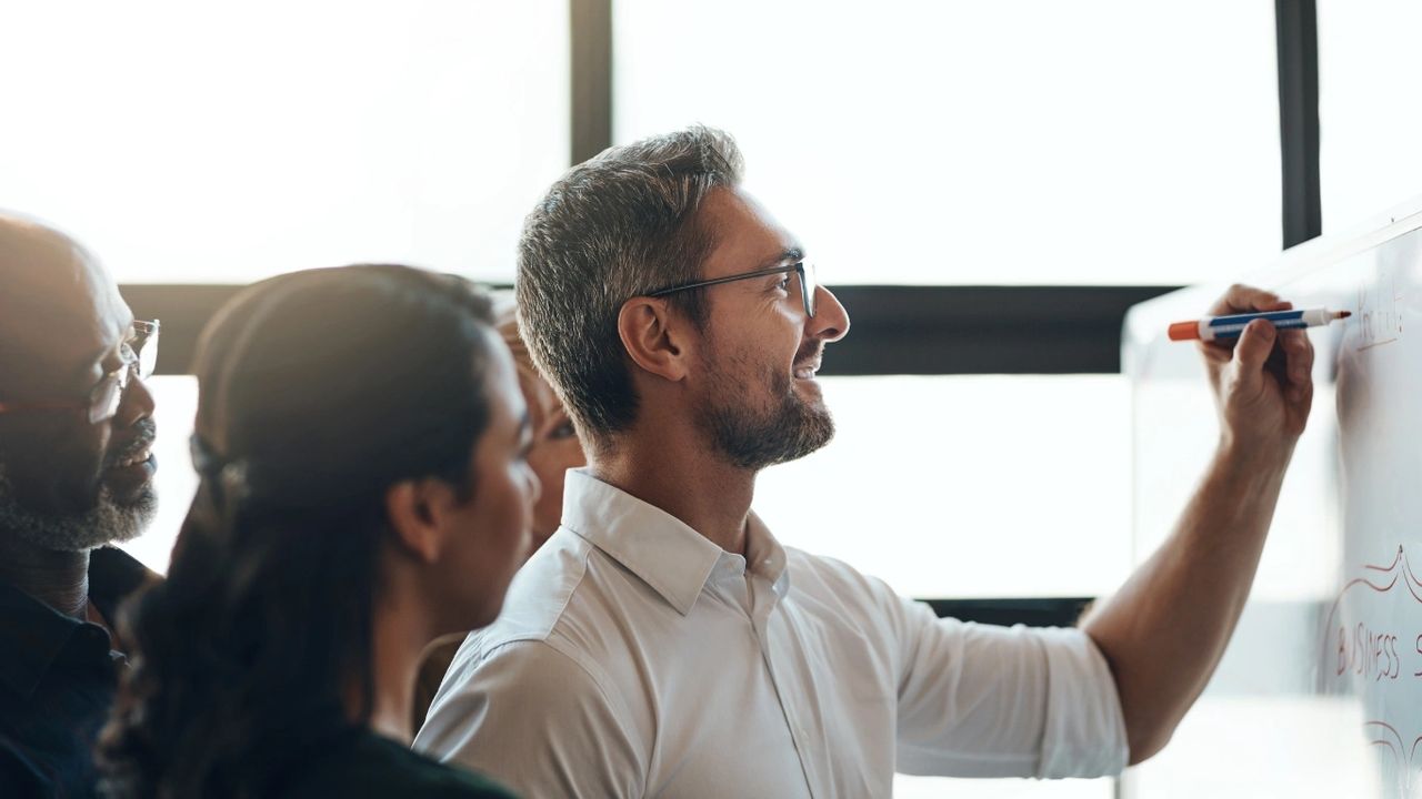 How to use Your Honesty for Global Success, a man writing on a white board with people watching