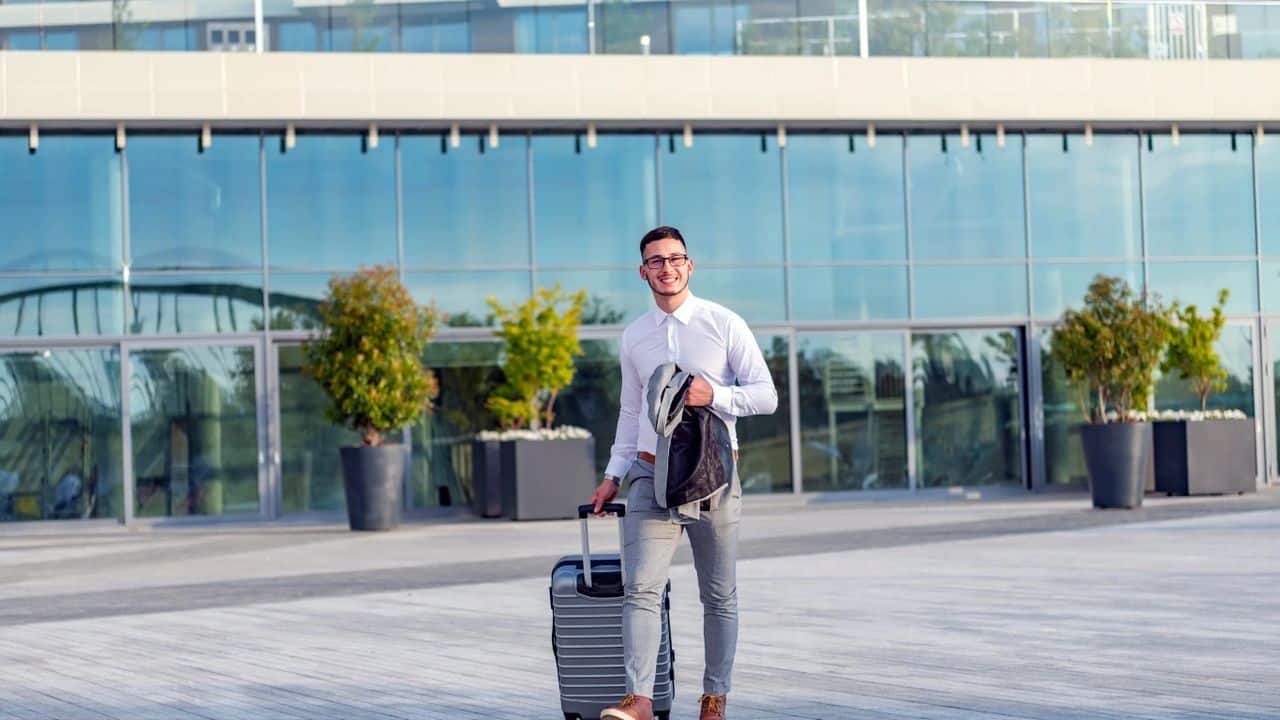 How to adapt easily to working in a new country, a man leaving airport pulling his case behind him