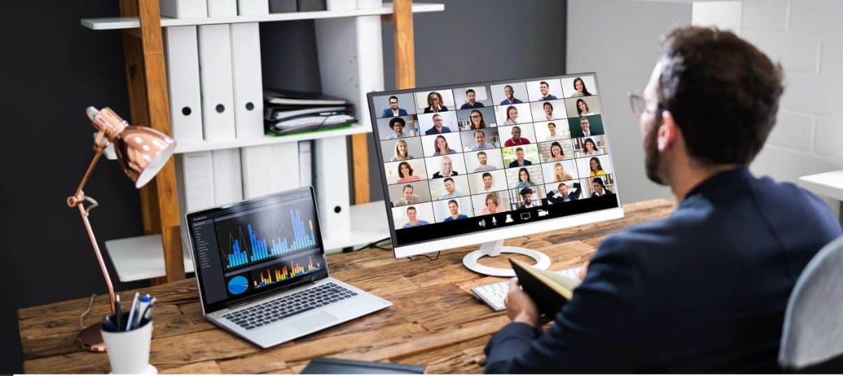 Man sitting at desk on Video Conference wit multiple people
