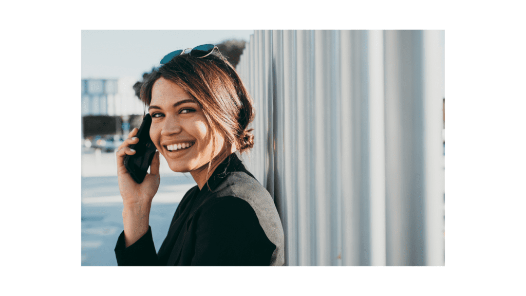 woman outside on phone smiling