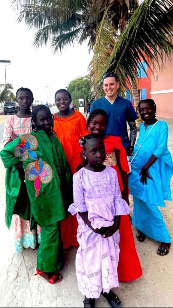 John Waller Biomed in Africa with women and children outside