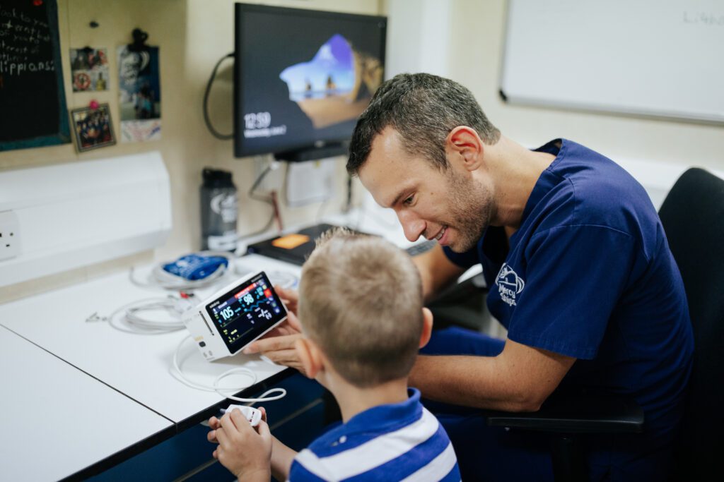 Guido Kortleven working as a Biomedical Technician with son and pulse oximeter
