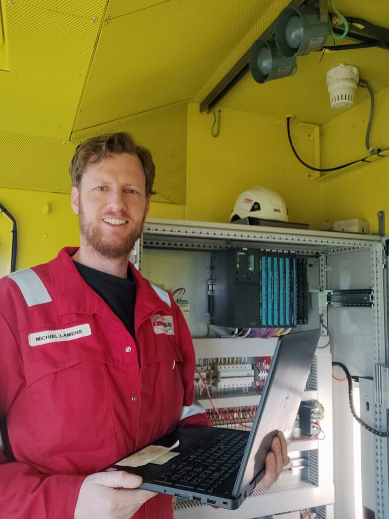 Michiel Lamens with laptop in control room working on offshore cranes
