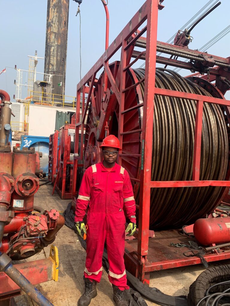 Kevin Chimezie Akparanta in front of coiled tubing