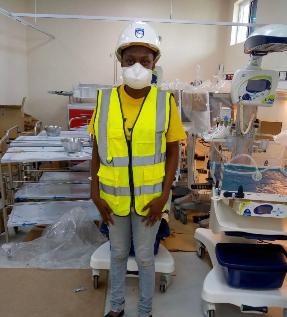 Ruth Otieno with equipment and philips hard hat