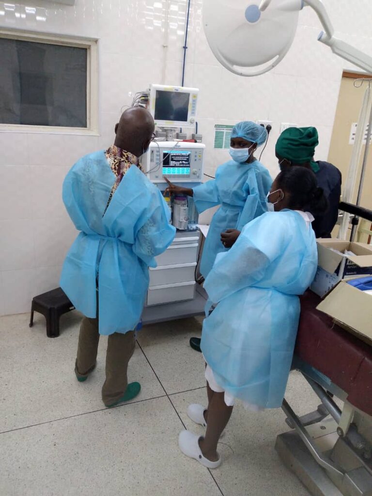 Yaa Amoakoa Frempong in ppe with colleagues demonstrating equipment