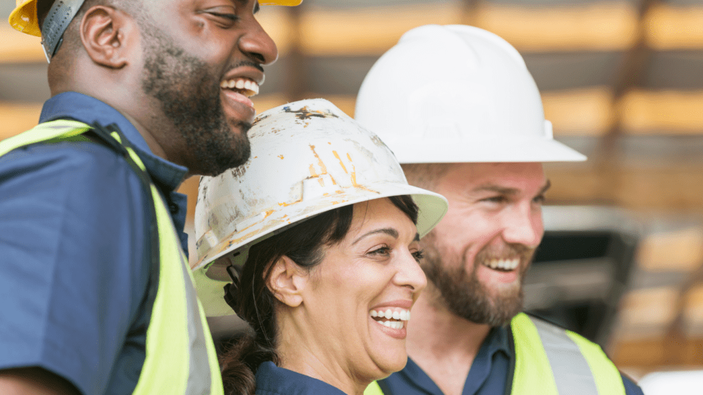 three engineers in hard hats laughing