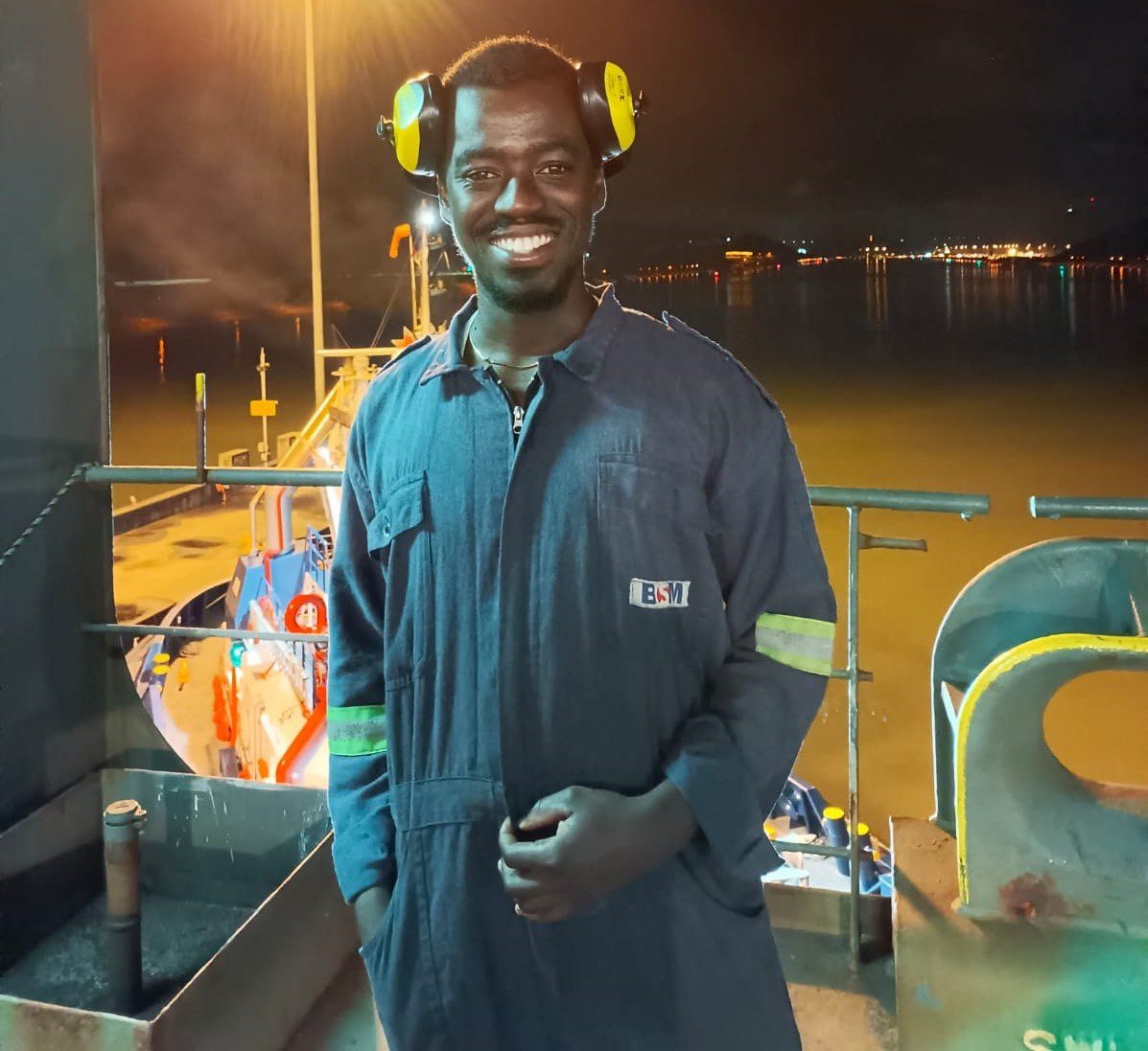 Kwadwo Marfo Marine Engineer on deck at night with port behind