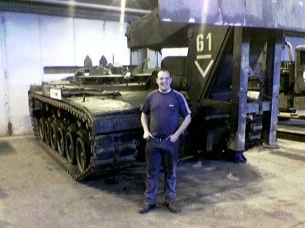 Phil McNicholas beside a tank