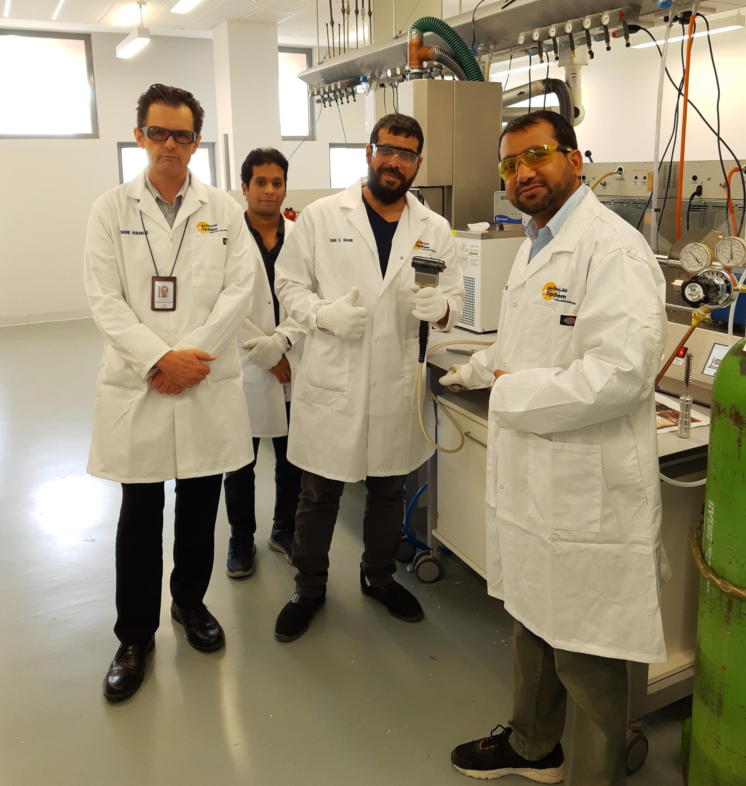 SYED INAYAT ALI SHAH in lab with colleagues all in PPE