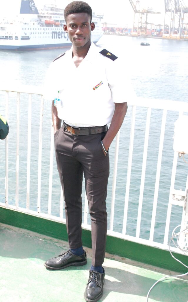 Wilson Gogo Marine Engineer in uniform on quay with ship behind