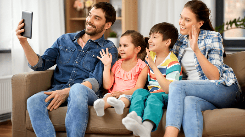 family on call sitting on sofa and waving