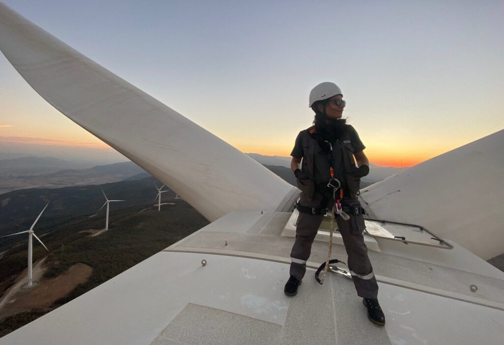 Songul Ogdum Power-Plant Specialist Wind and Hydroelectric on top of turbine