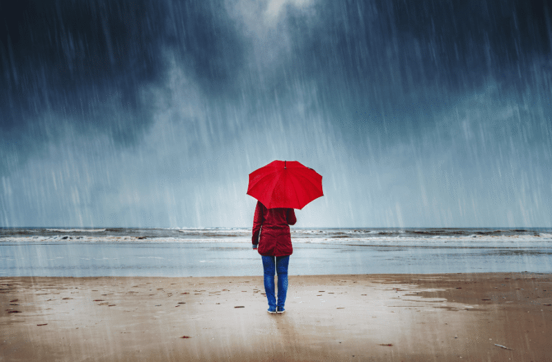 person on beach in rain
